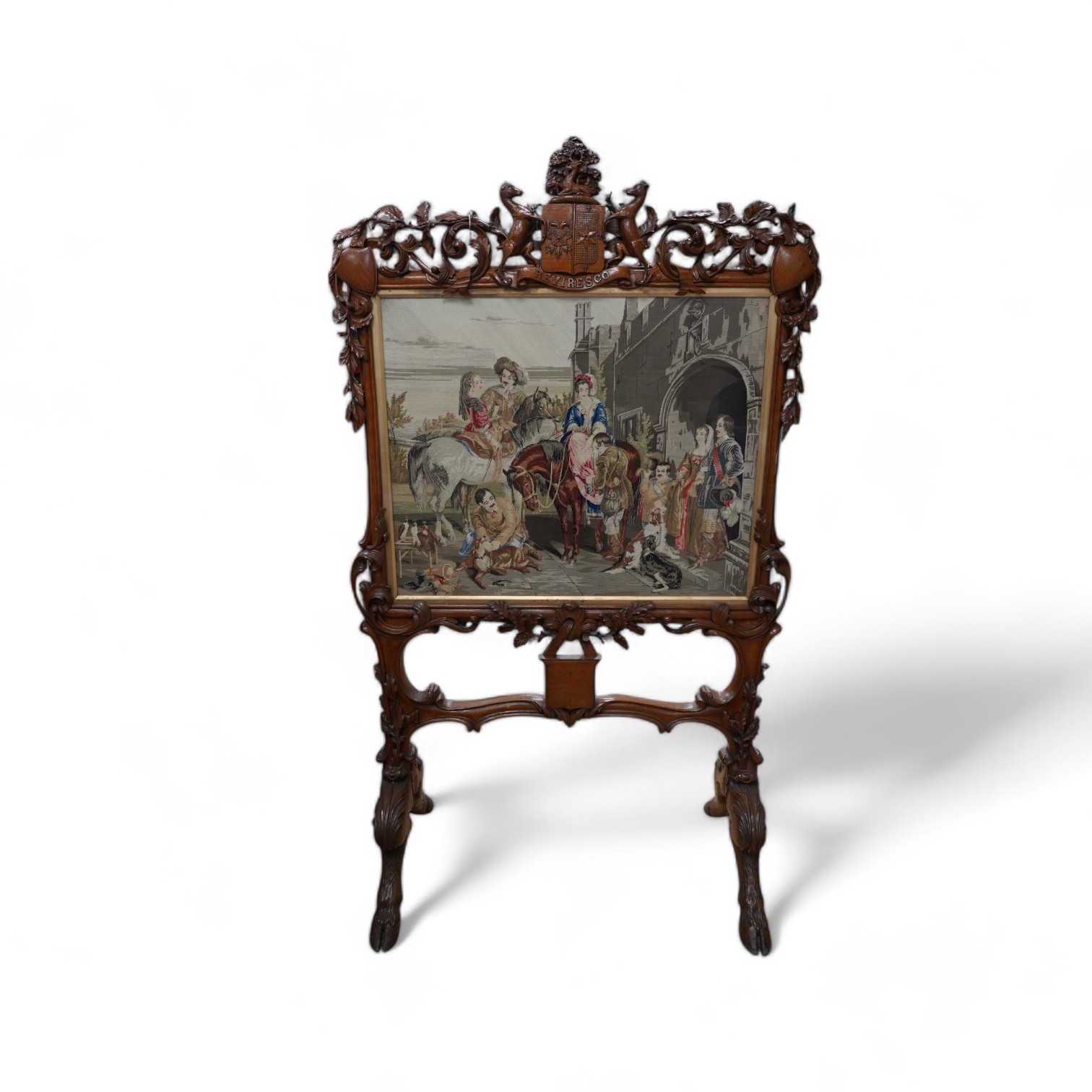 A large 19th century ornately carved oak fire screen, carved with hoof feet and a finely worked petite point panel of a Jacobean family preparing for a falconry hunt. 148cm high, 87cm wide, petite point panel 69cm wide,